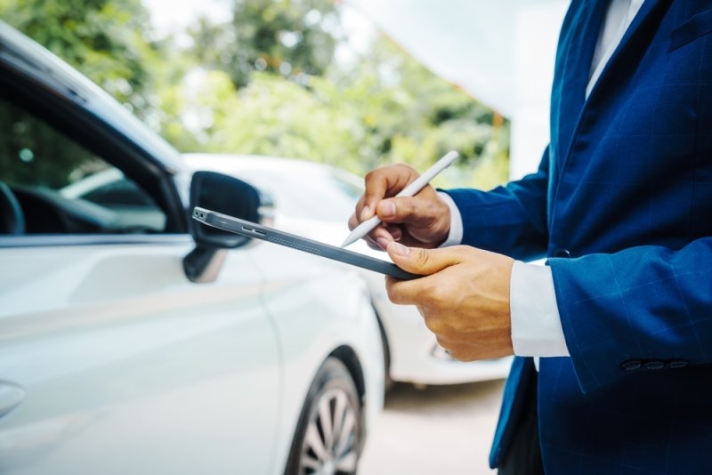 Car insurance agent checking the car details on his tablet