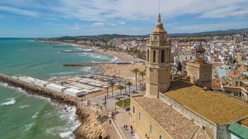 Aerial view of Sitges coastal town and the Iglesia de San Bartolome y Santa Tecla church on a sunny day in Sitges, Catalonia, Spain.
