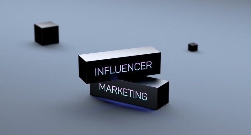 3D illustration of glowing black blocks labeled “Influencer Marketing” on a minimalist background, representing influencer and digital marketing strategies.
