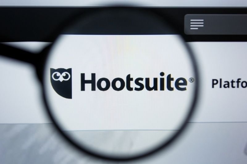 Close-up of the Hootsuite website logo viewed through a magnifying glass, symbolizing social media management and marketing tools.