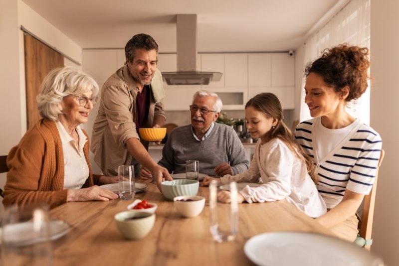 Happy multigenerational family gathering around a kitchen table