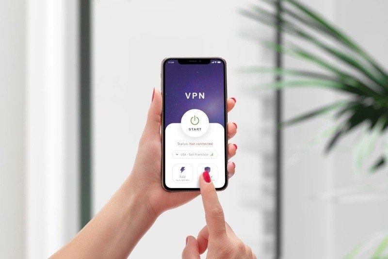Person holding a smartphone displaying a VPN app interface, demonstrating secure internet browsing and online privacy protection.