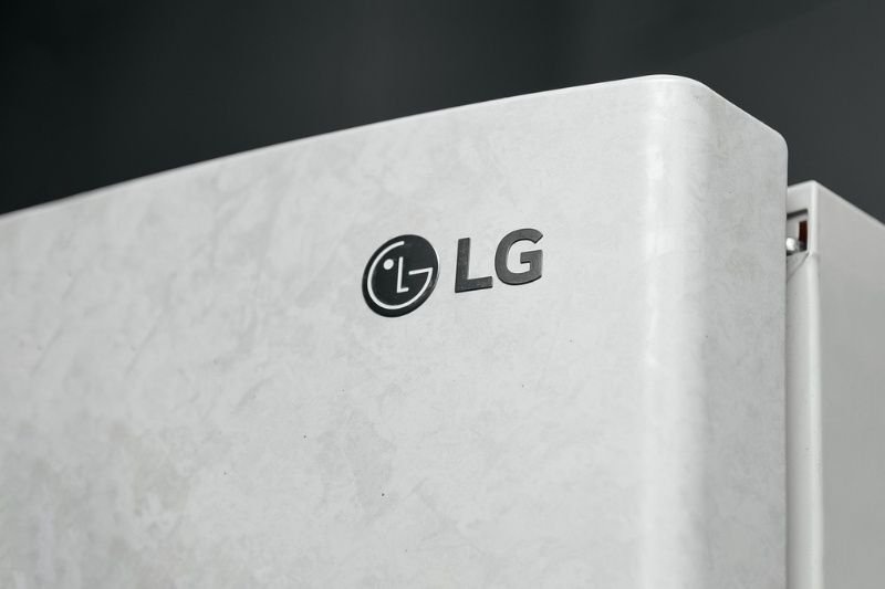 Close-up of an LG refrigerator logo on a white appliance door, highlighting the brand and product design.