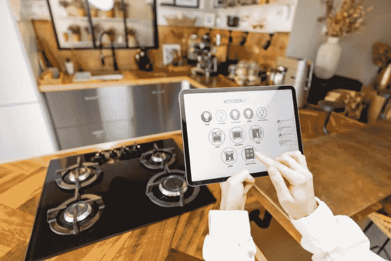 Woman with a tablet in hand with her smart kitchen connected devices