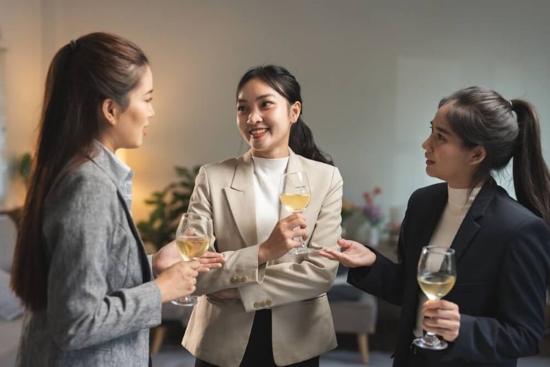 Group of 3 professional corporate women engaging in a social networking events