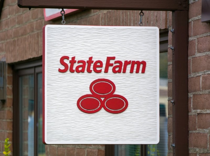 State Farm insurance sign and logo hanging outside a shop