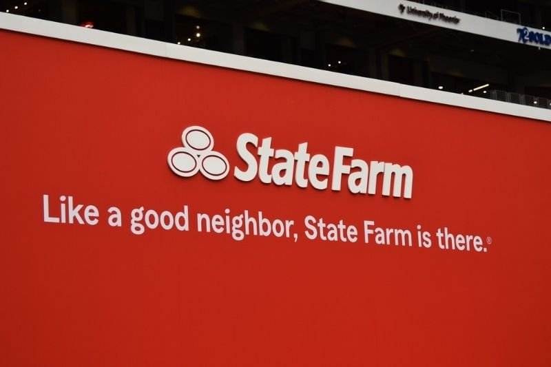 tate Farm branding displayed on a large red billboard featuring the slogan "Like a good neighbor, State Farm is there".