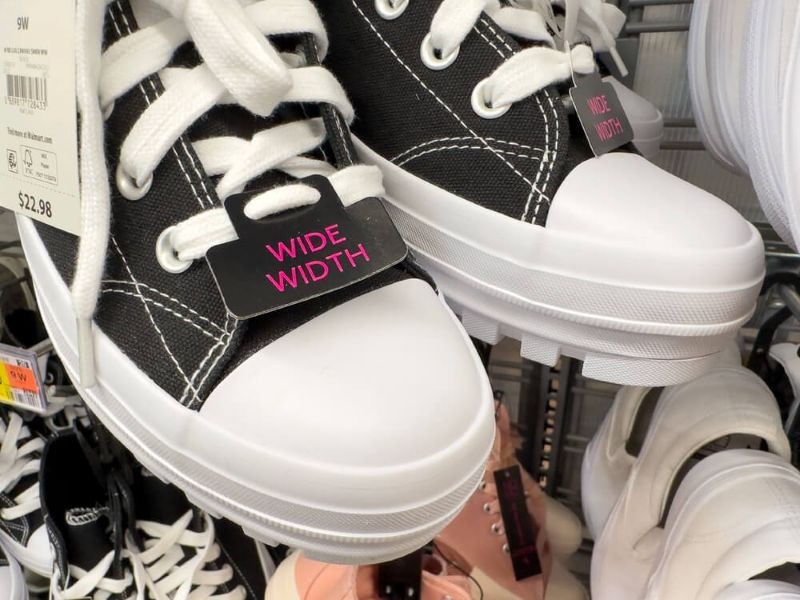 Closeup of casual sneakers with Wide Width tag attached to it