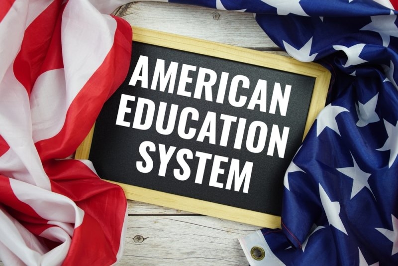 American Education System text message with USA flag on wooden background