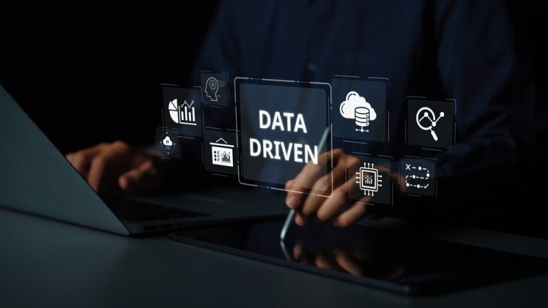 Person using a laptop with digital data analytics and decision-making icons.