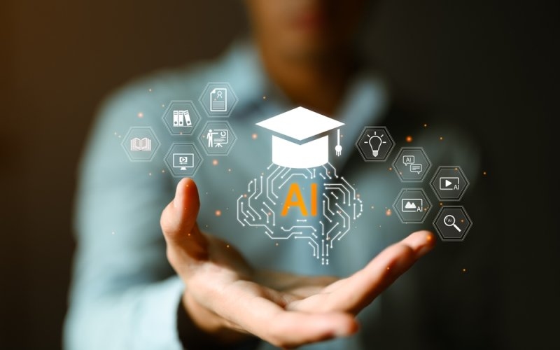 Professional hands holding AI brain circuit with graduation cap surrounded by hexagonal education icons including books, videos and learning tools. 