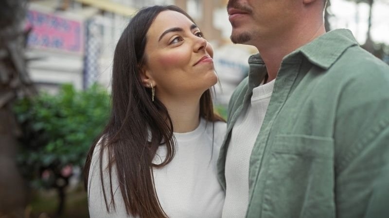 Woman smiling warmly at her partner during an outdoor moment.