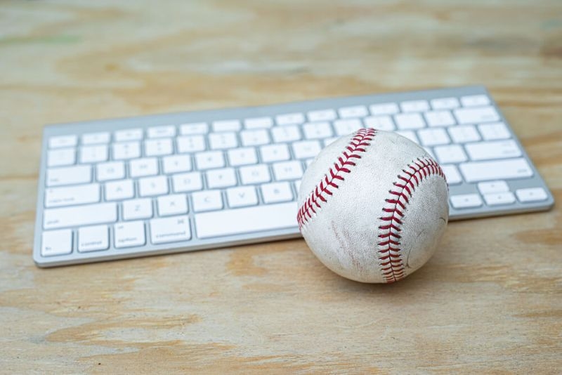 baseball and keyboard on a wooden table