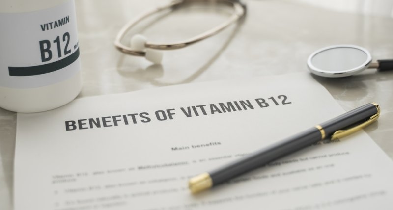 bottle of vitamin B12 supplements and a printed leaflet on the table stating the benefits of vitamin B12
