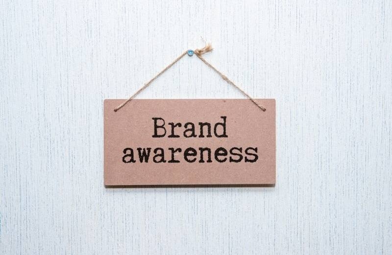 "Brand Awareness" written on a brown card hanging on the wall.