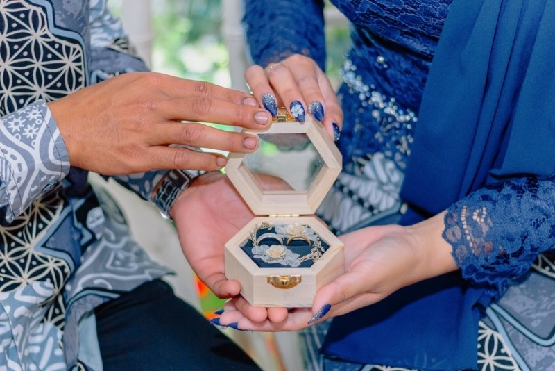 Bride and groom holding a wooden ring box