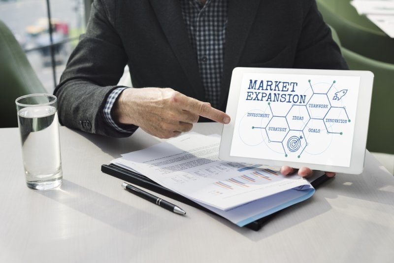 Business professional pointing at a tablet displaying a 
