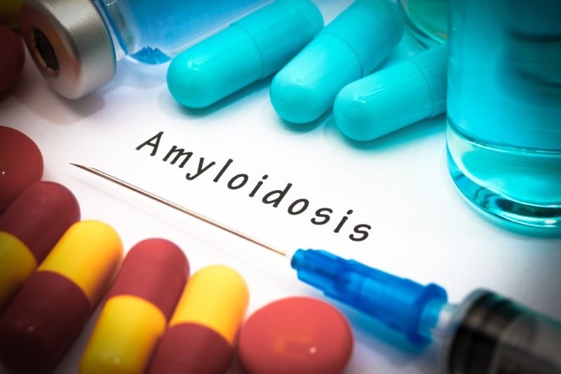 A medical-themed image featuring capsules, medications, and a syringe surrounding the word “Amyloidosis.”