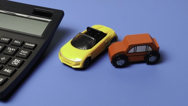 miniature cars with calculator on a table