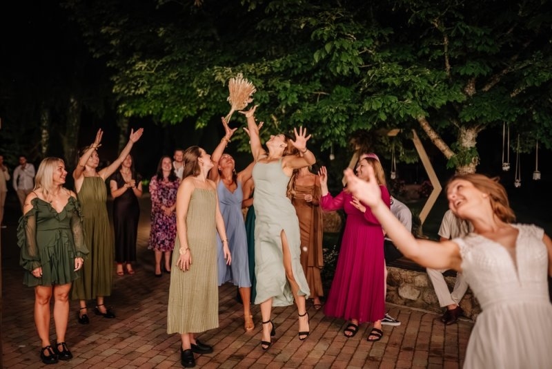 group of women jump to catch the wedding bouquet