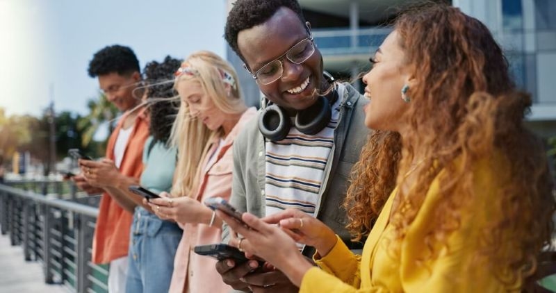 gen z students  happy looking at  phone inside college campus 