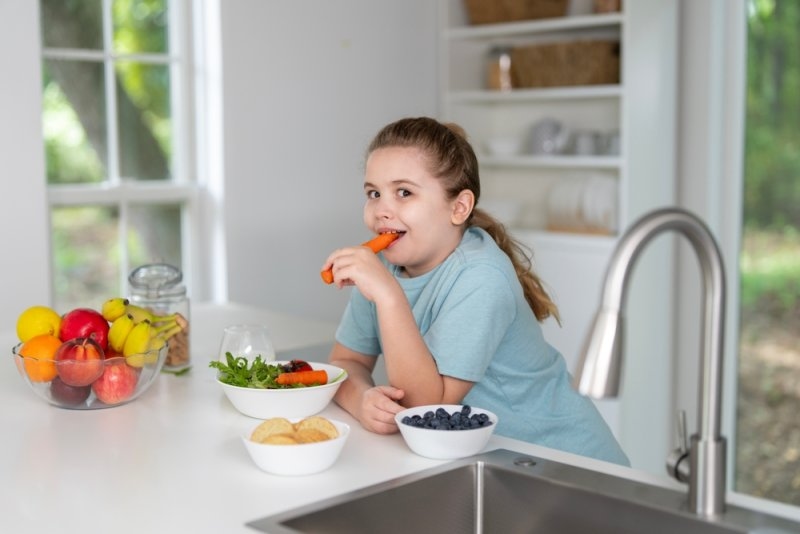 Child eating healthy fruits and vegetables