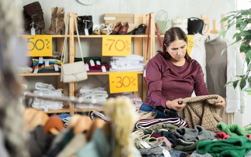 Shopper comparing prices while looking for clearance deals