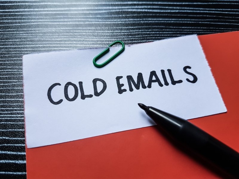 Text cold emails printed on a paper clipped to a red paper