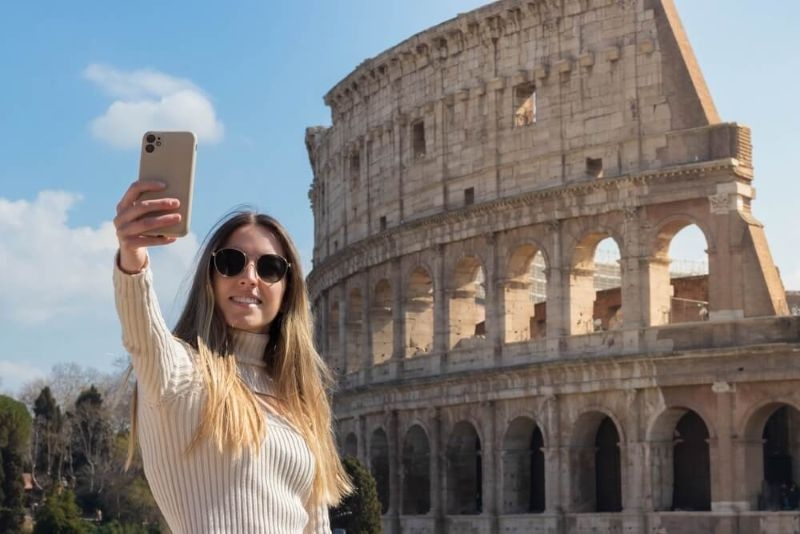 Woman taking selfie at the colosseum in rome