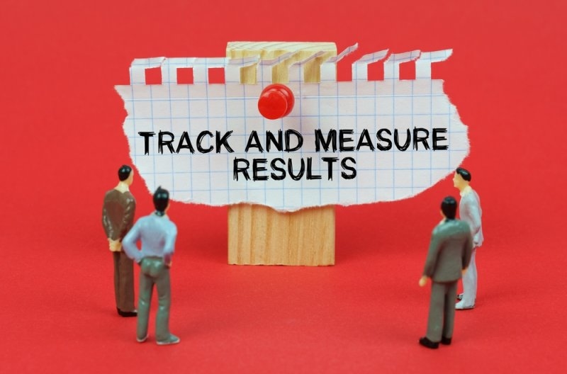 On a red background are miniature figures of people looking at an ad with the inscription - Track And Measure Results.