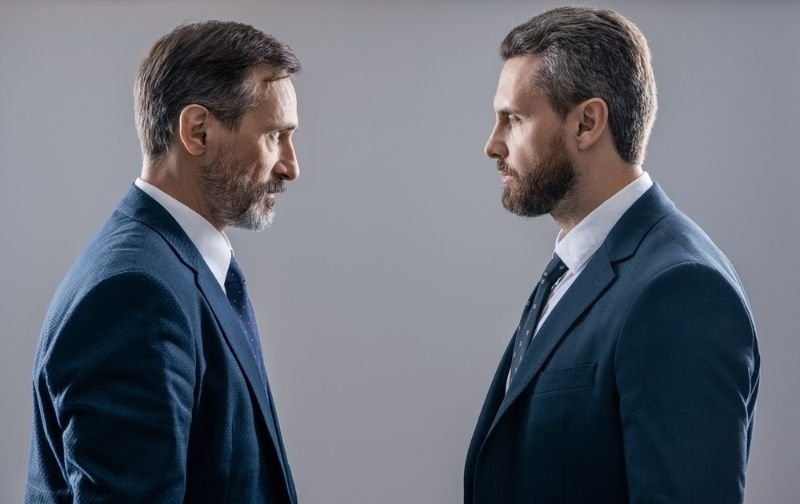 Two business professionals facing off in a competitive business rivalry.