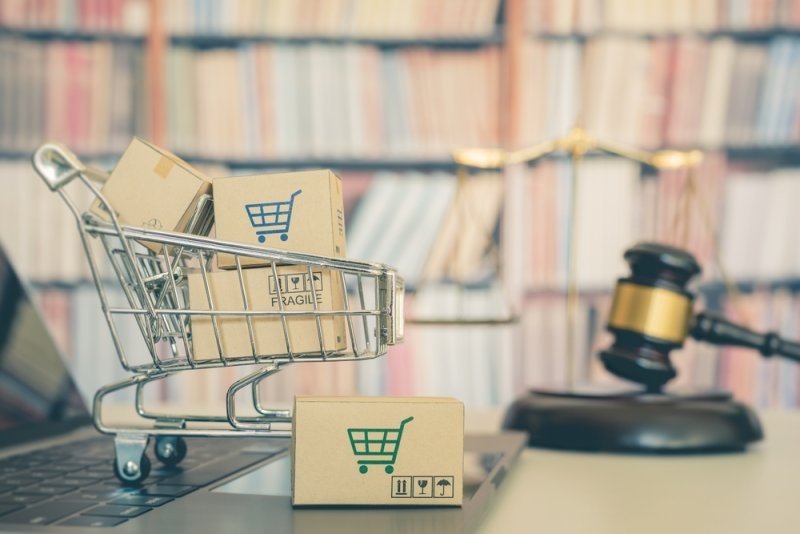 Shopping cart with purchased goods and a judge's gavel representing consumer rights and legal protection in the marketplace.