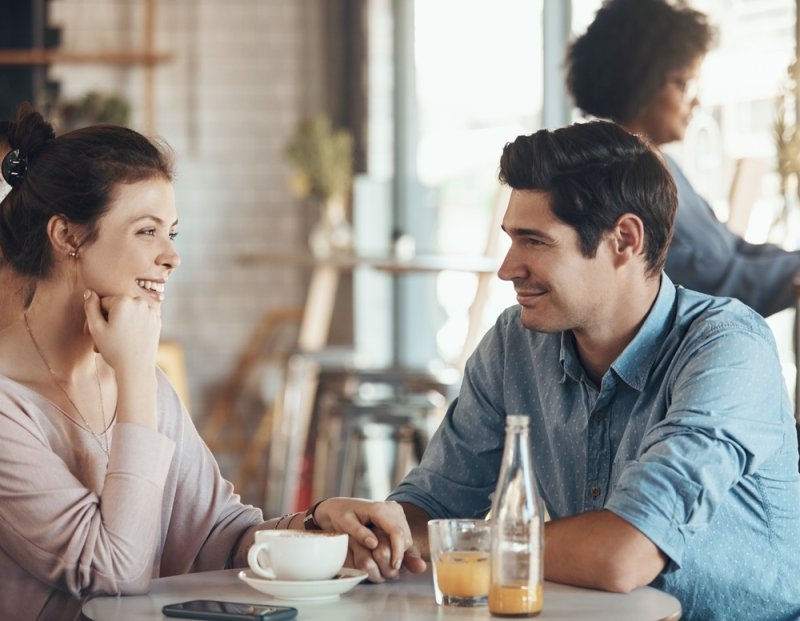 couple and holding hands in cafe for date