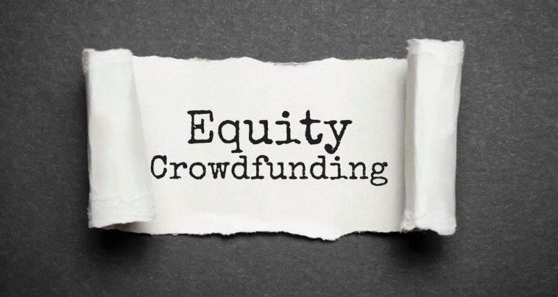 A paper sign displaying “Equity Crowdfunding.”