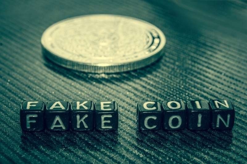Fake coin concept with labeled blocks and a cryptocurrency token.