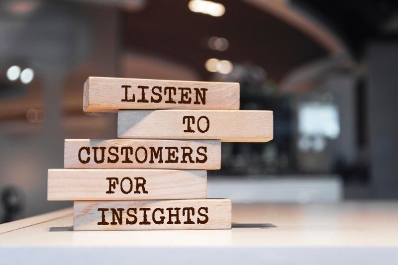 Wooden blocks with words 'Listen to customers for insights'.