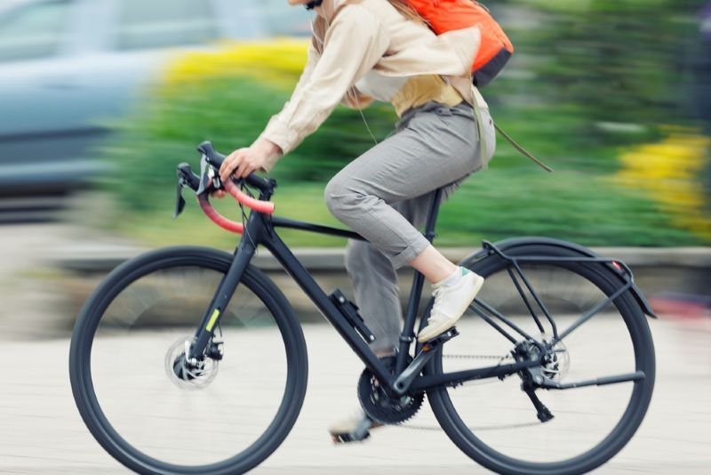 woman riding cycle on road 