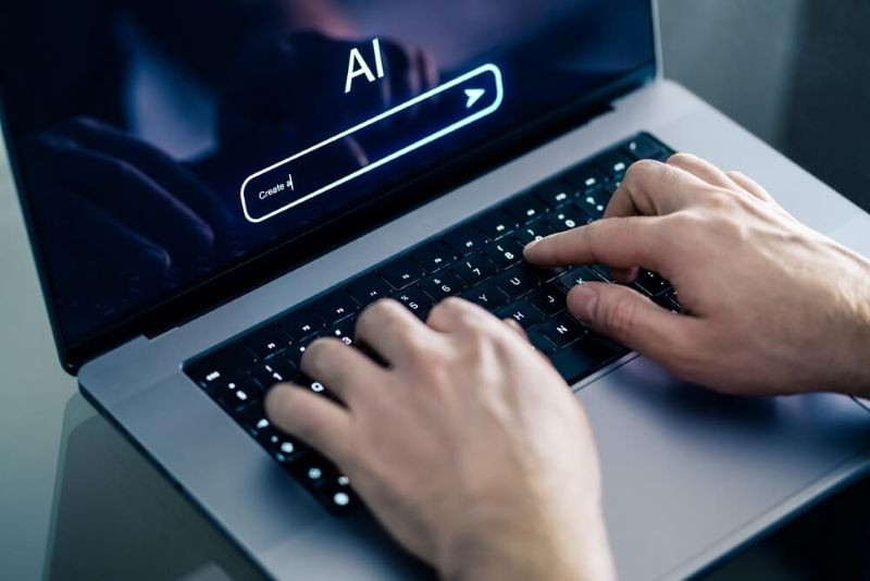 man using ai tool on laptop on table