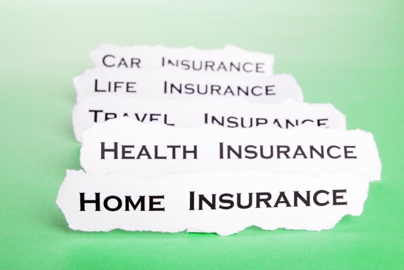 Torn paper labels listing car, life, travel, health, and home insurance on a green background.