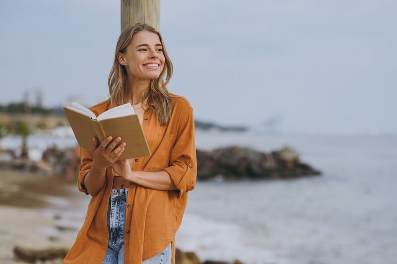 woman feeling happy while reading book on digital detox tour