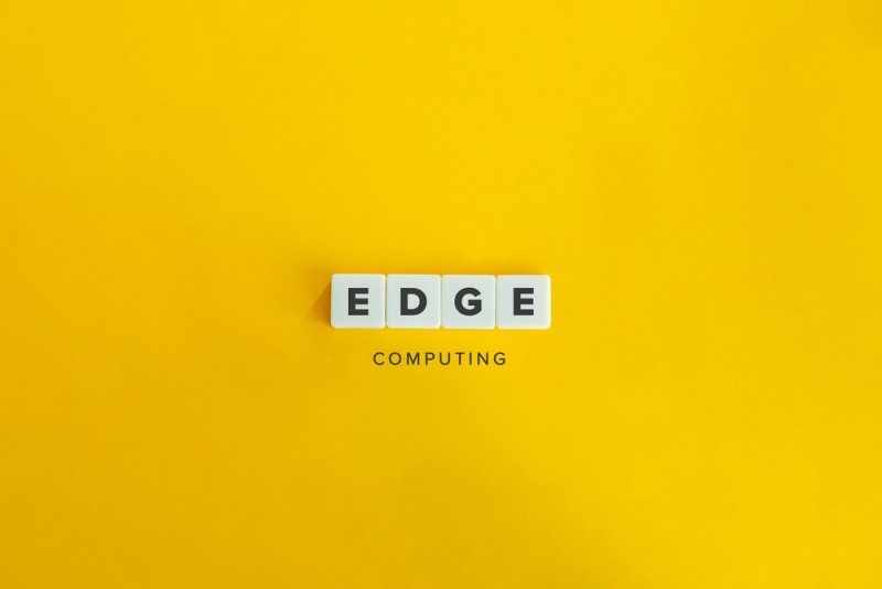 “EDGE COMPUTING” spelled with letter tiles on a bright yellow background.