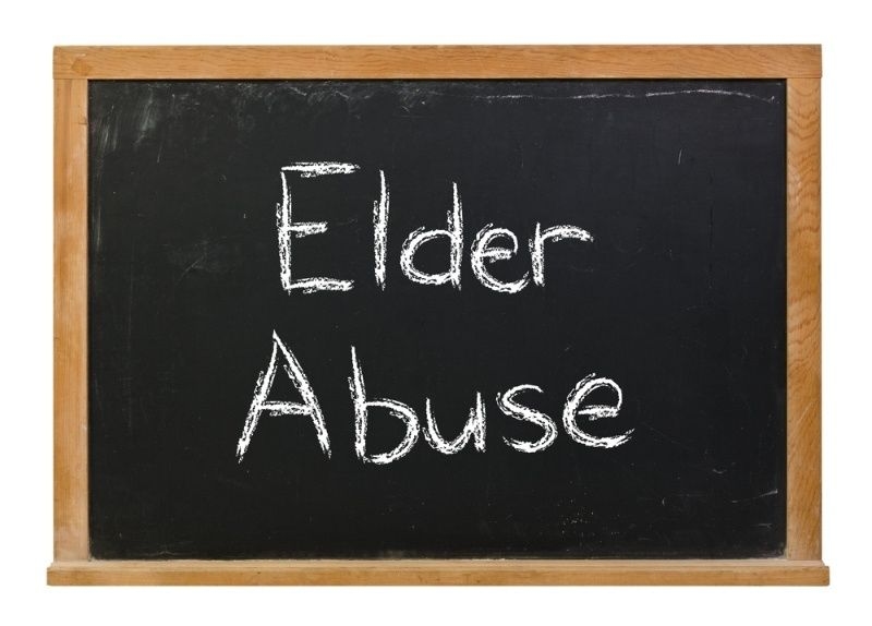 Blackboard with the words ‘Elder Abuse’ written in white chalk.