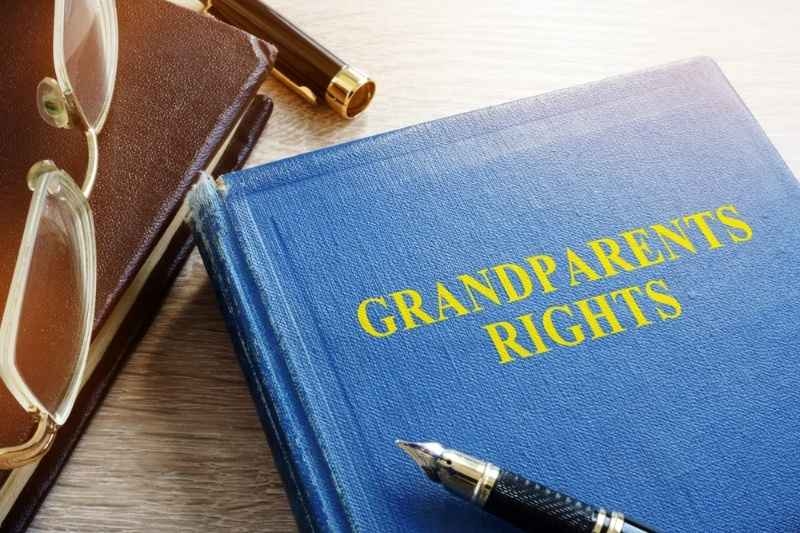 Book titled ‘Grandparents Rights’ with eyeglasses and a pen on a desk.