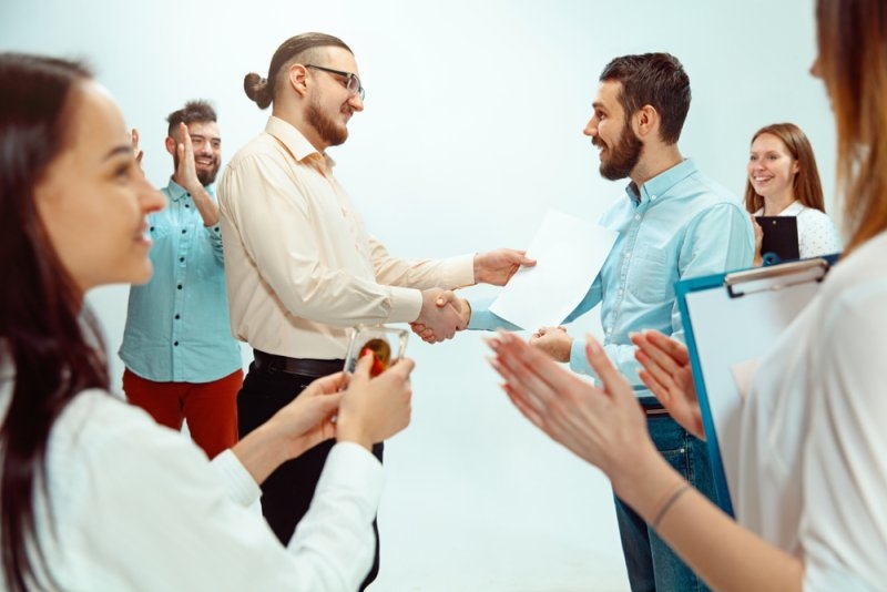 Boss approving and congratulating young successful employee