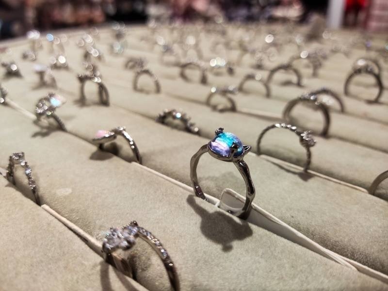 Display of engagement rings and gemstone jewelry arranged in a retail showcase.