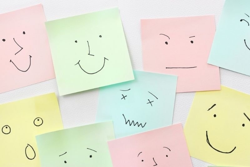 Top view image of notes with sketches of face emotions.