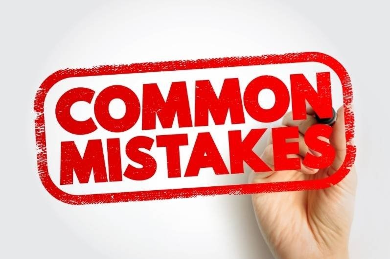Hand stamping the words "Common Mistakes" in bold red.
