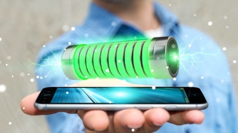 Businessman on blurred background using green battery with lightnings 3D rendering.
