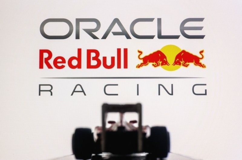 Oracle Red Bull Racing F1 Team Logo on Computer Screen with Miniature Toy Car Silhouette.