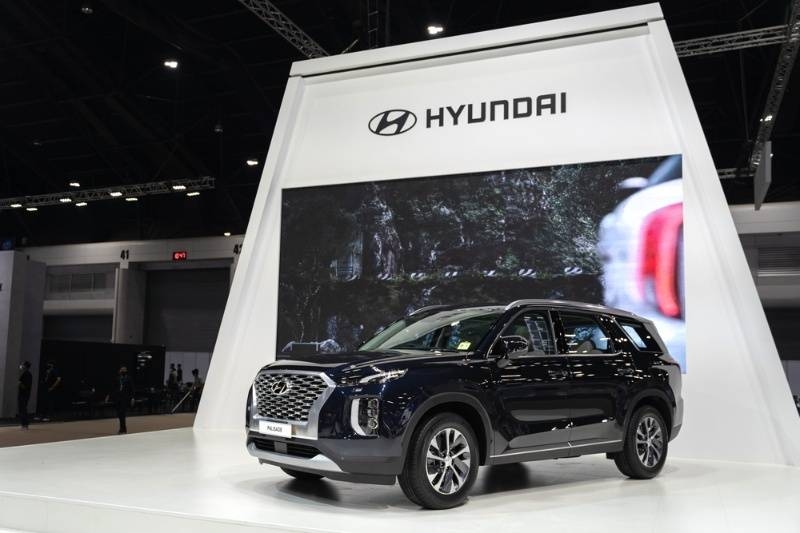 Black Hyundai SUV showcased on a display platform at a car expo.
